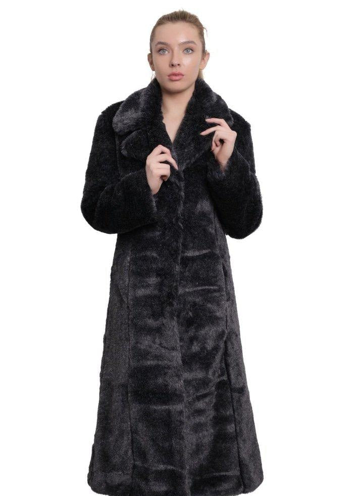 Woman wearing a long dark fur coat on a white background