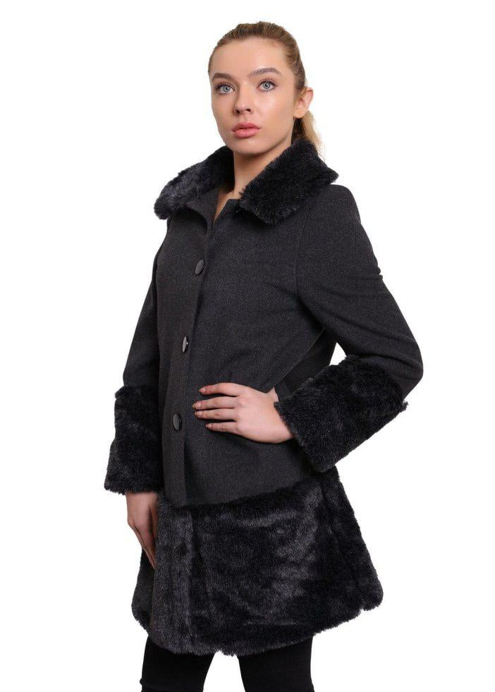 Woman wearing a black coat with fur trim on a white background