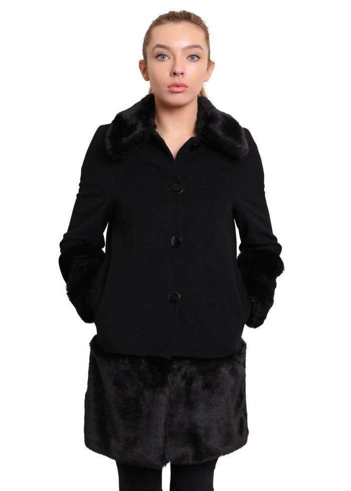Woman wearing a black coat with fur trim on a white background