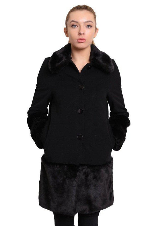 Woman wearing a black coat with fur trim on a white background