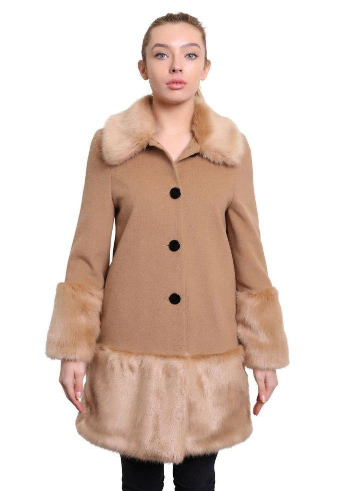 Woman wearing a tan coat with fur trim on a white background