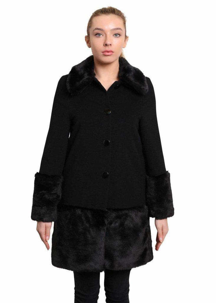 Woman wearing a black coat with fur trim on a white background