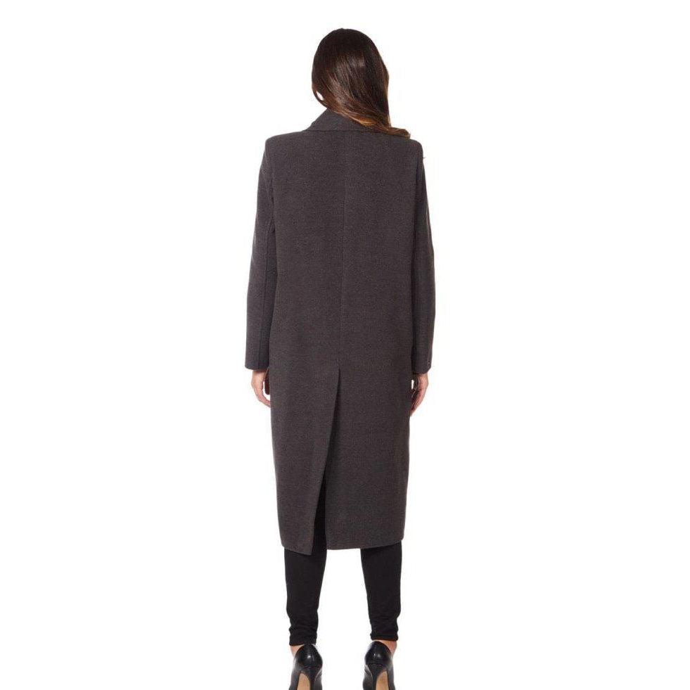 Woman wearing a long dark gray coat on a white background