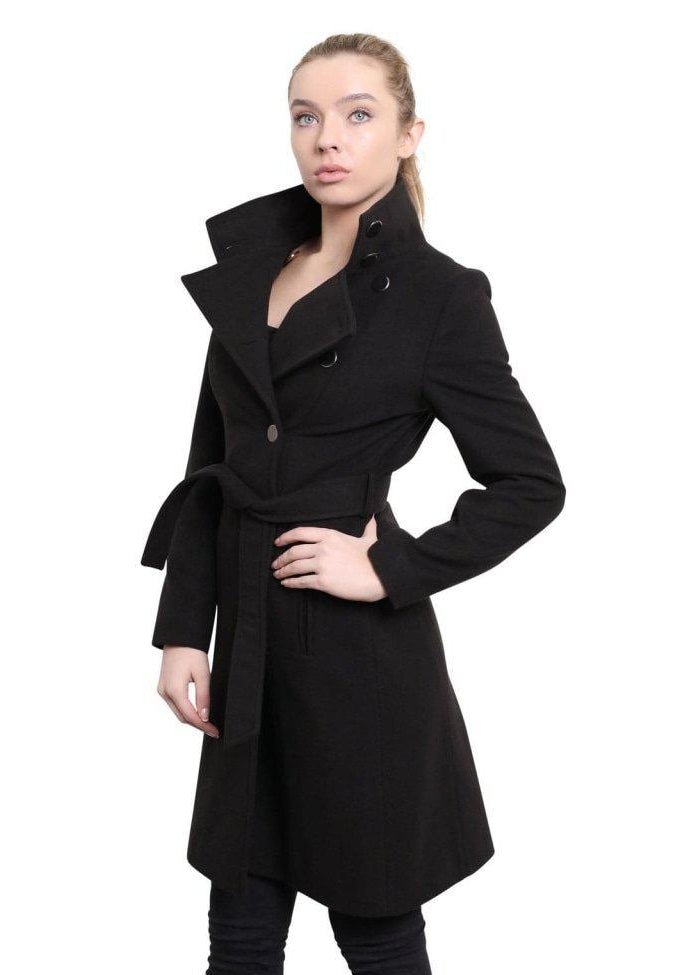 Woman wearing a black coat with a belt, standing against a white background.