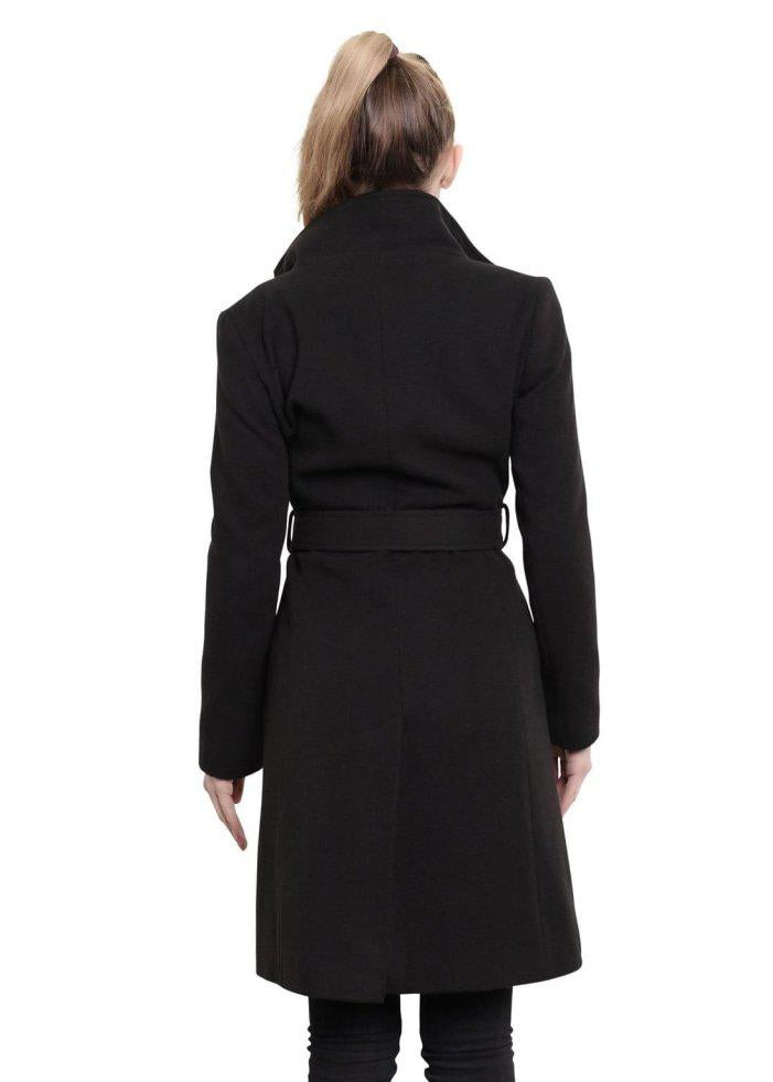 Woman wearing a black coat with a belt, standing against a white background.