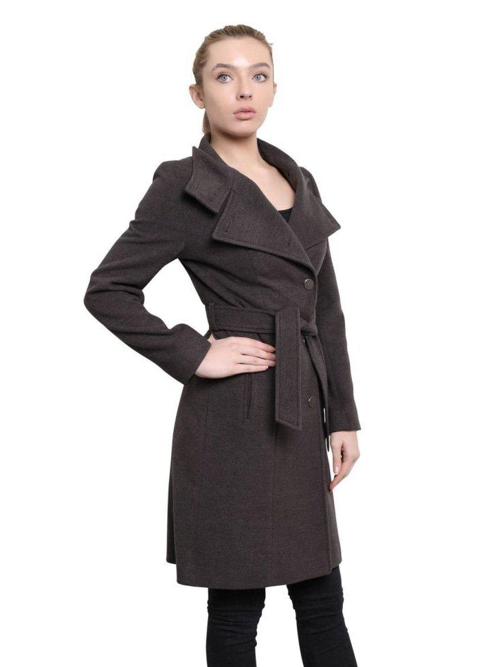 Woman wearing a brown coat with a belt on a white background