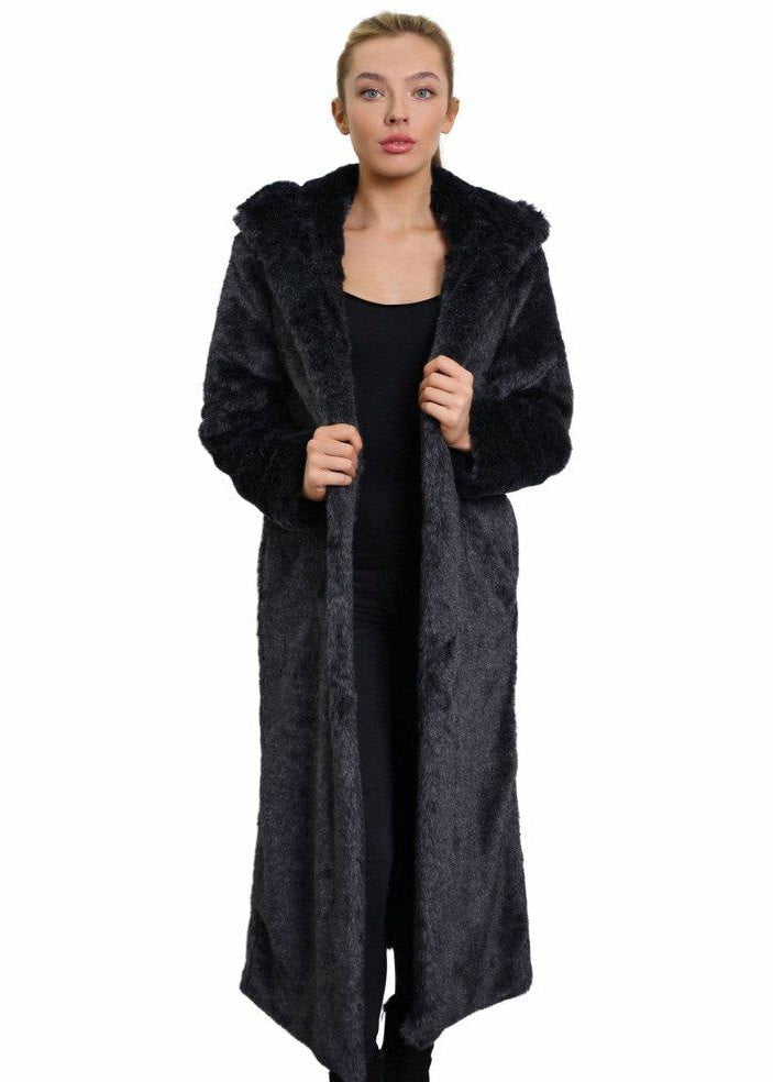 Woman wearing a long black fur coat on a white background