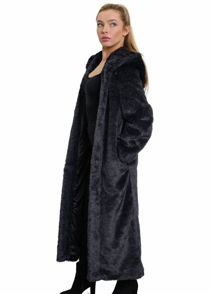 Woman wearing a long black fur coat on a white background