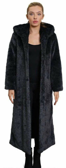 Woman wearing a long black coat with a hood on a white background