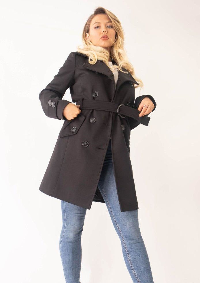 Woman wearing a black coat with a white background