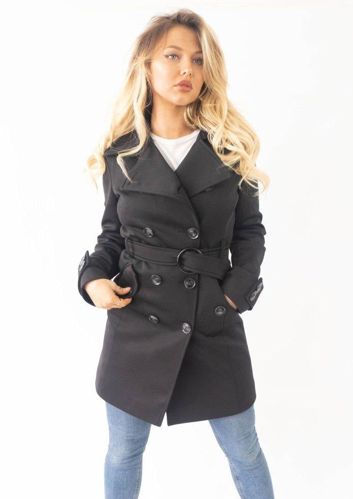 Woman wearing a black coat with a white background