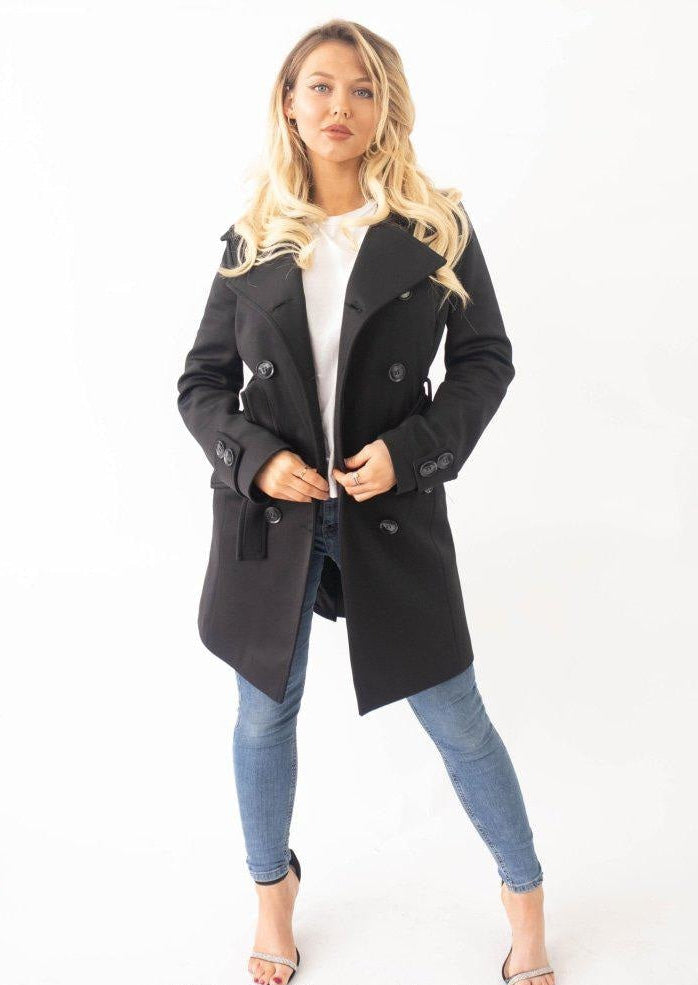 Woman wearing a black coat with a white background