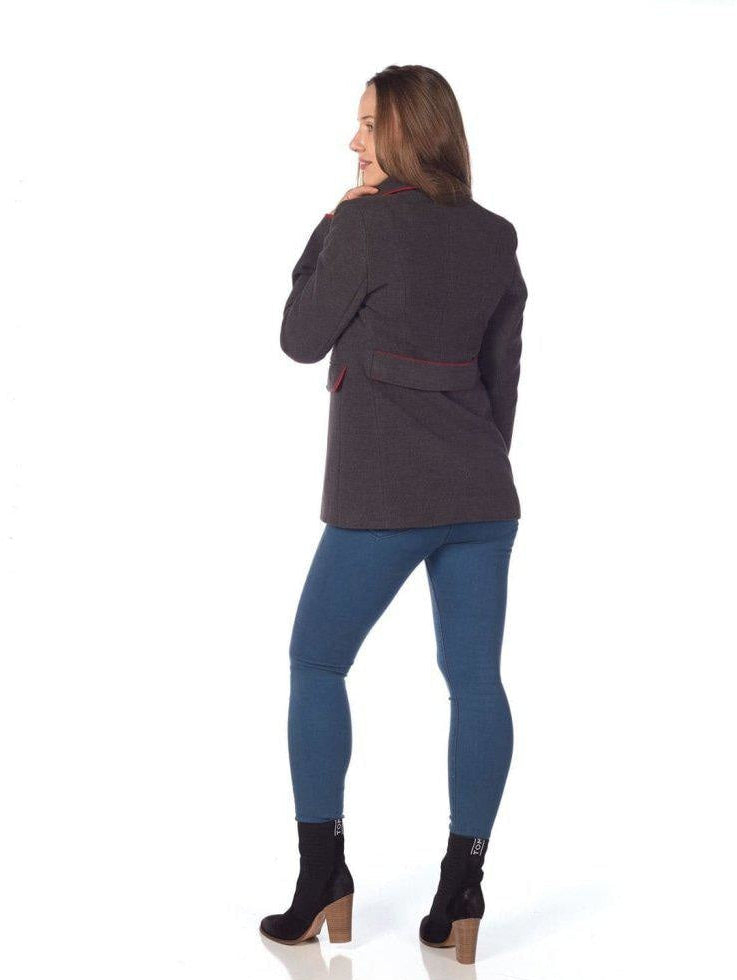 Woman wearing a dark gray jacket and blue leggings on a white background