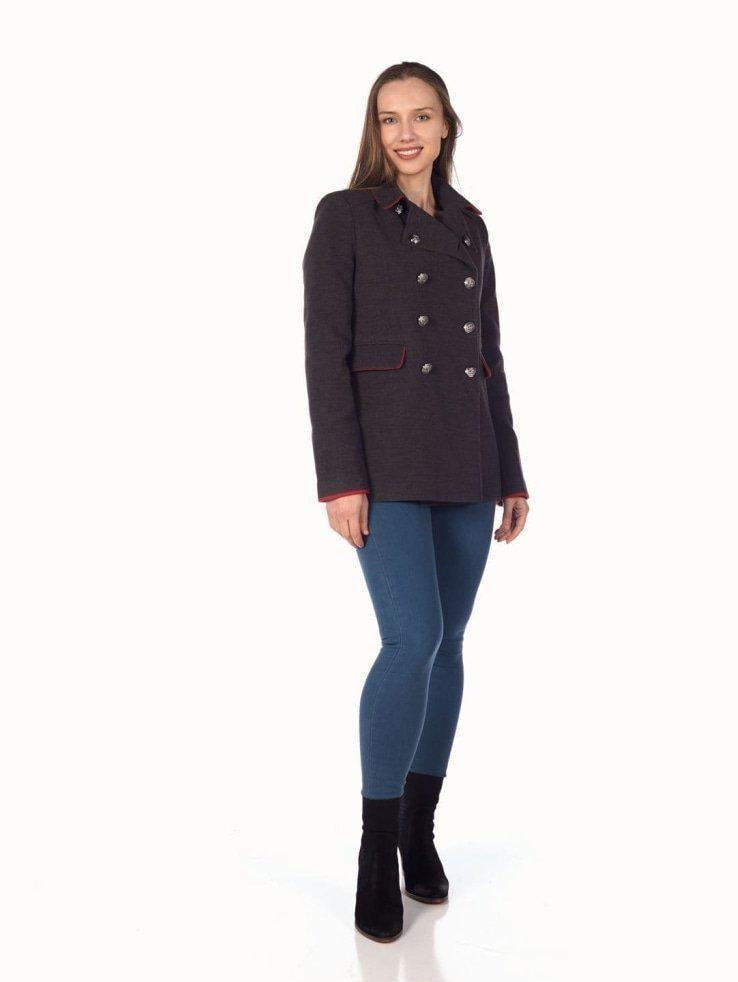 Woman wearing a dark coat and blue pants on a white background