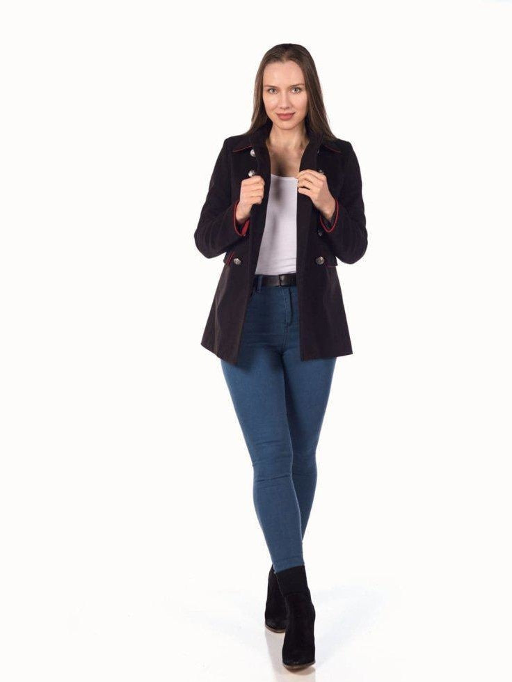 Woman wearing a black coat, white shirt, and blue jeans on a white background
