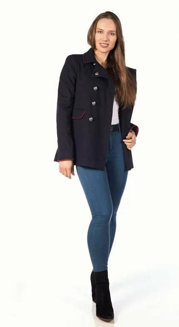 Woman wearing a black coat standing against a white background.