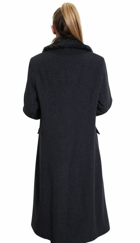 Person wearing a long black coat on a white background