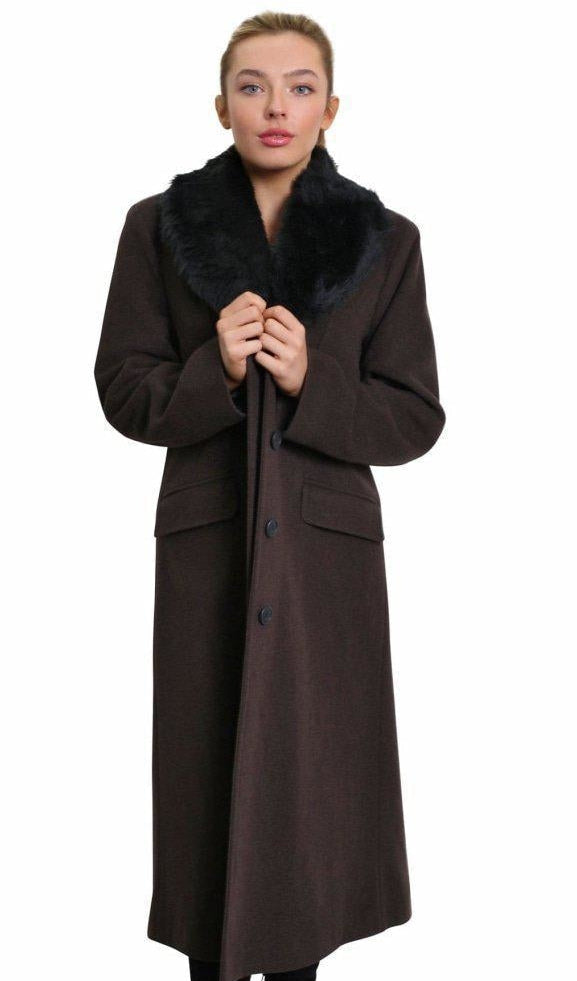 Woman wearing a long brown coat with fur collar on a white background