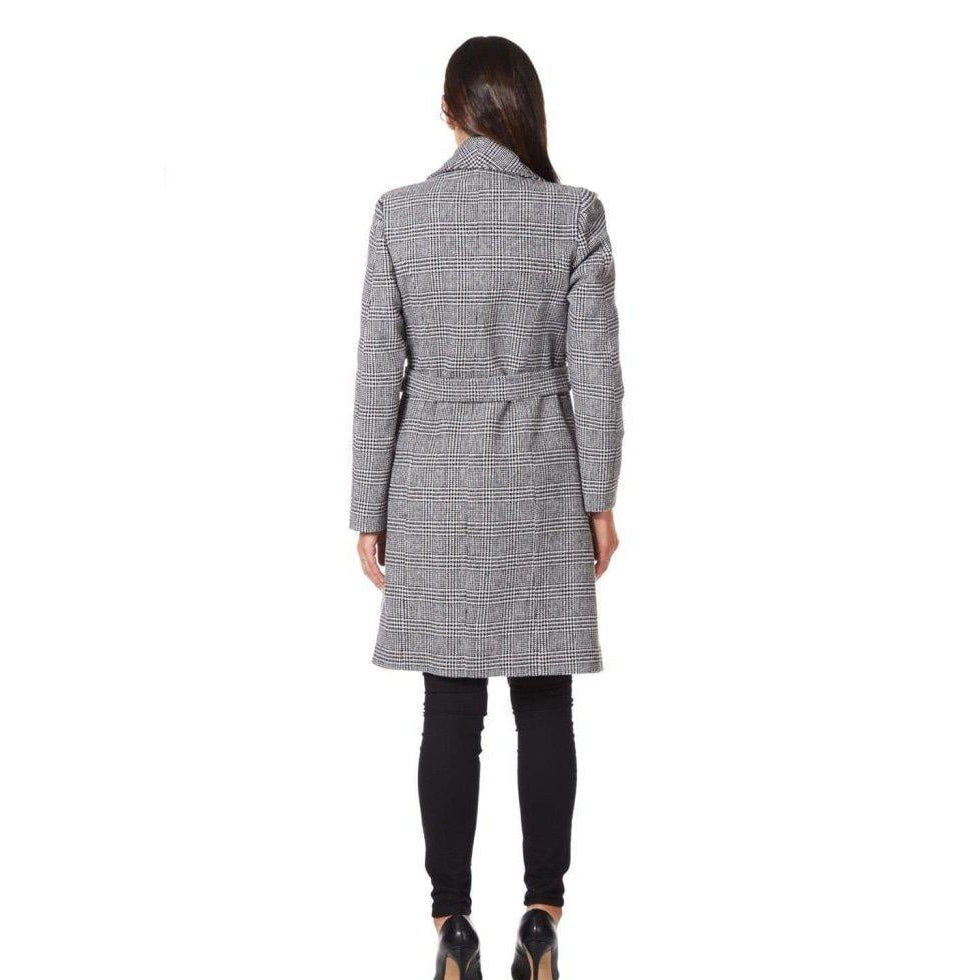 Woman wearing a gray houndstooth patterned coat on a white background