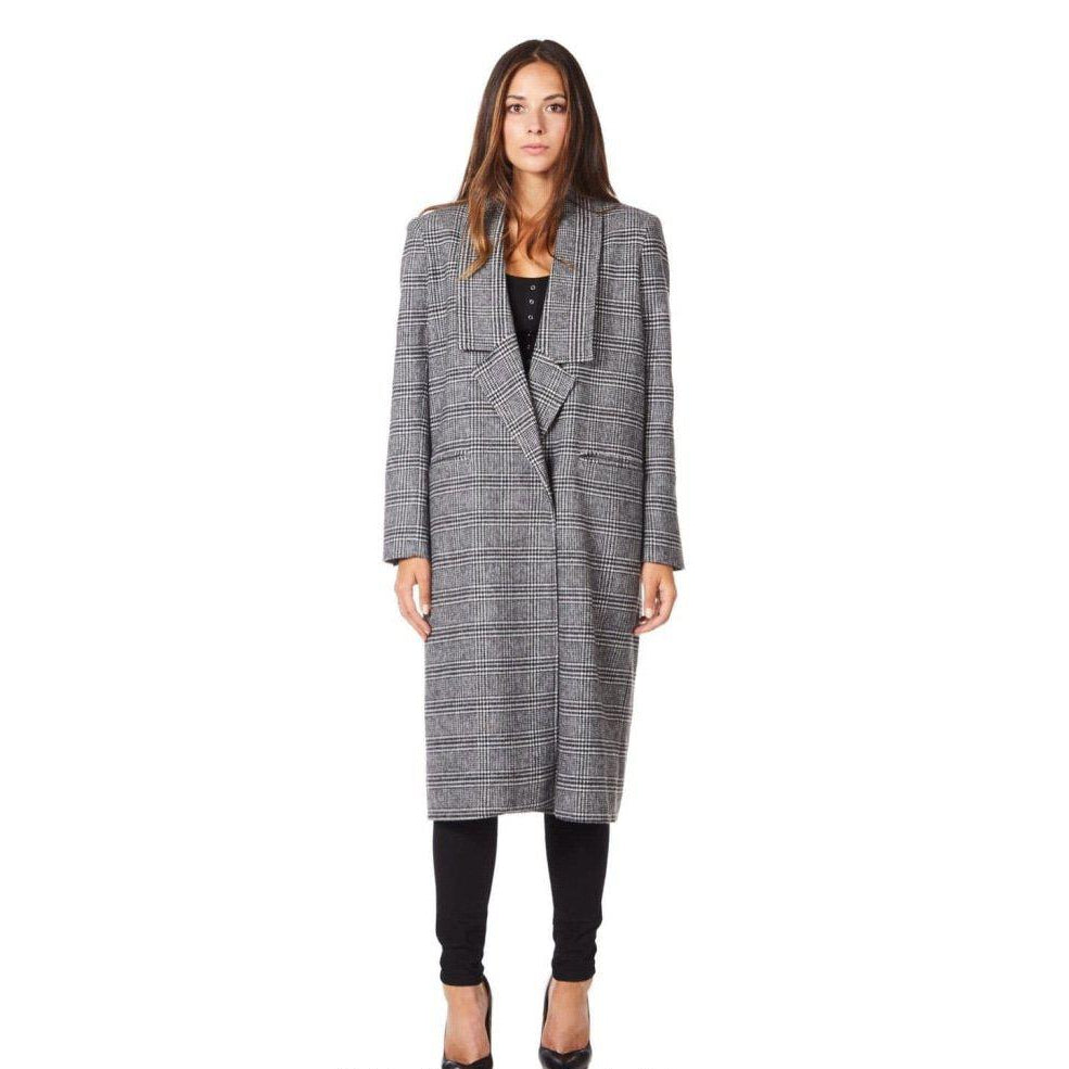 Woman wearing a long, checkered coat on a white background
