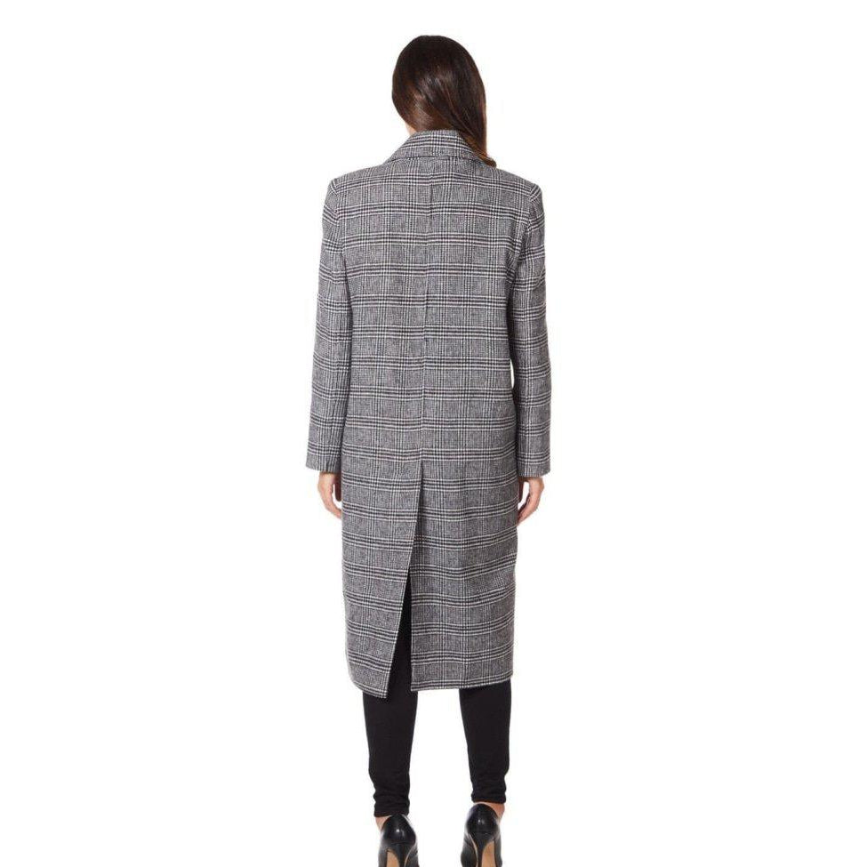 Woman wearing a gray checkered coat on a white background
