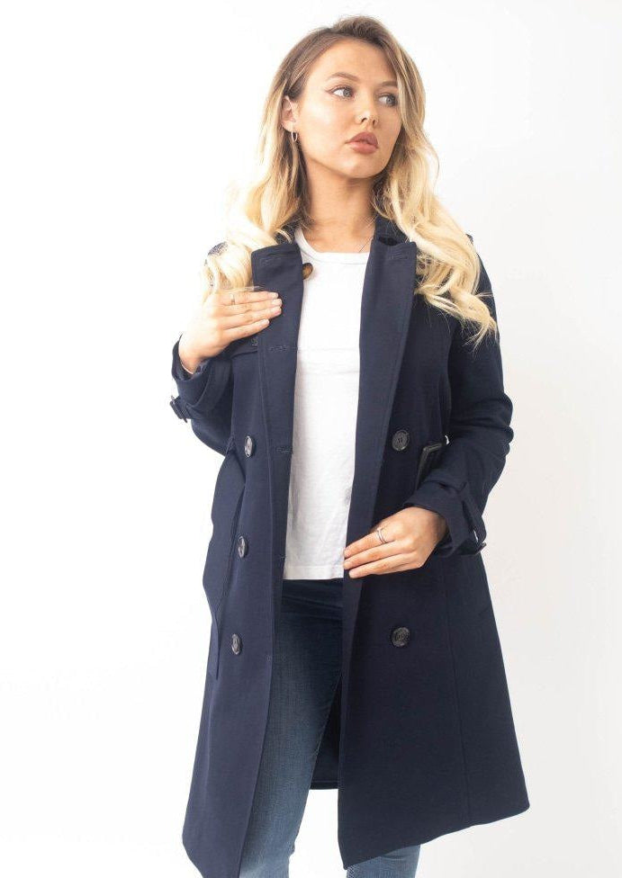 Woman wearing a navy blue coat on a white background