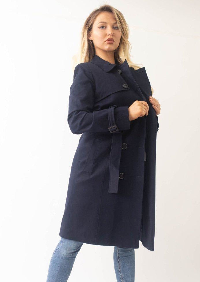 Woman wearing a navy blue coat on a white background