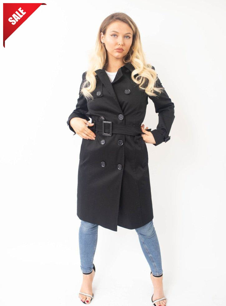 Woman wearing a black trench coat on a white background