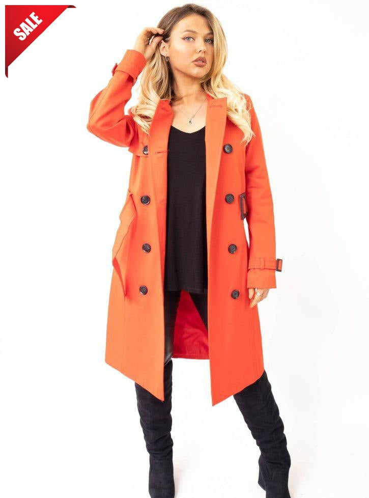 Woman wearing an orange coat with a 'Sale' label on a white background