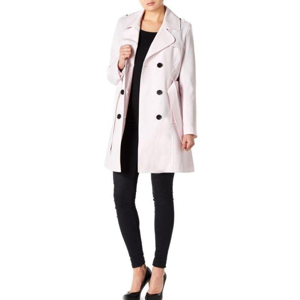 Person wearing a light pink coat with black buttons on a white background