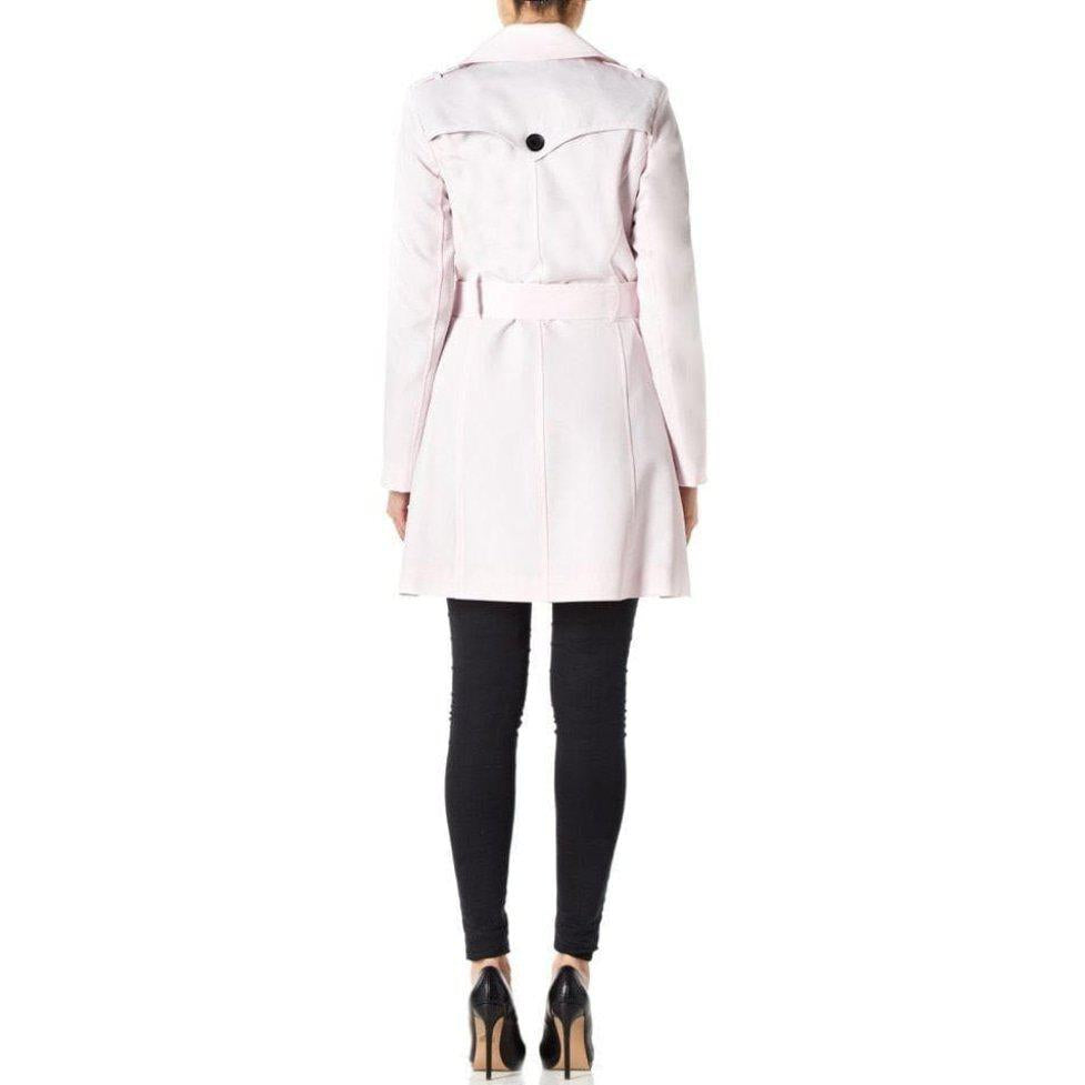 Person wearing a light pink trench coat on a white background