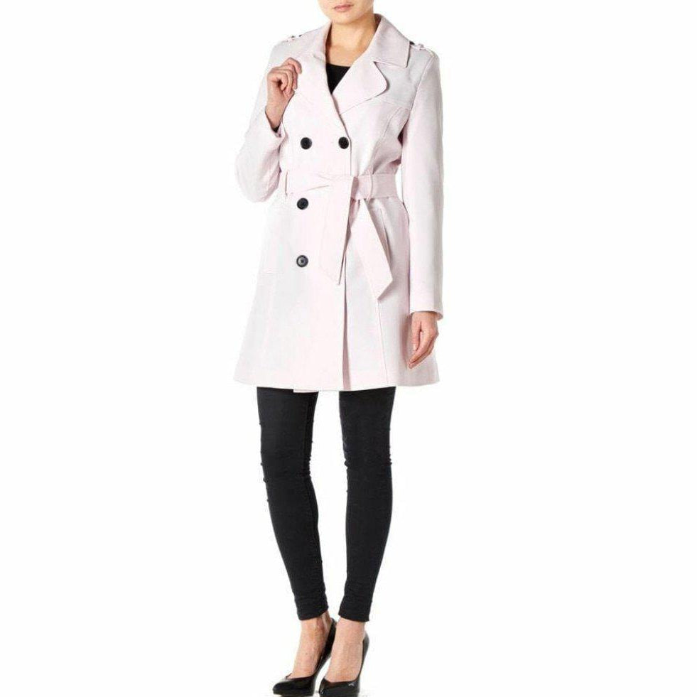 Woman wearing a light pink trench coat on a white background