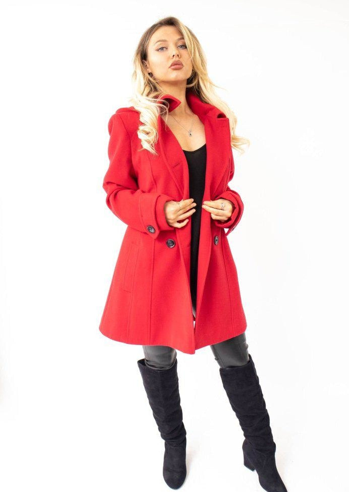 Woman wearing a red coat and black boots on a white background