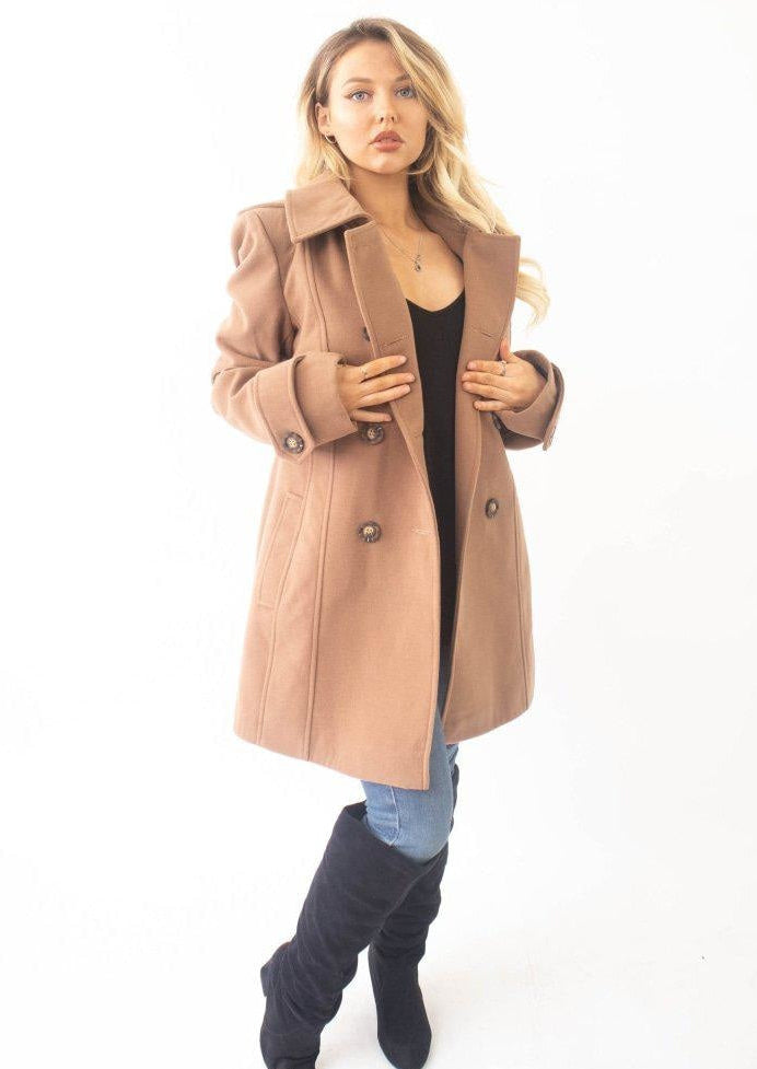 Woman wearing a beige coat on a white background