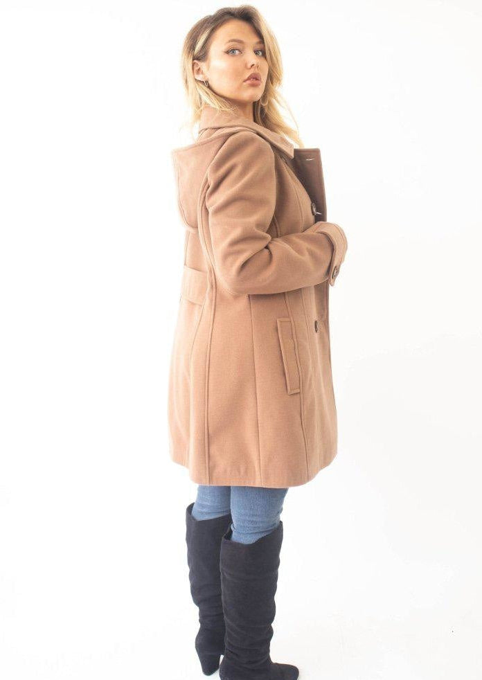 Woman wearing a beige coat with a white background