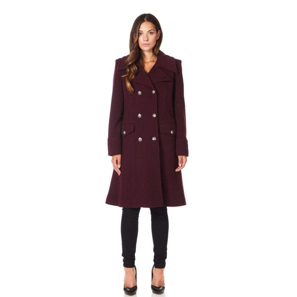 Woman wearing a burgundy coat with silver buttons on a white background