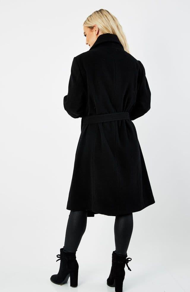 Woman wearing a black coat on a white background.