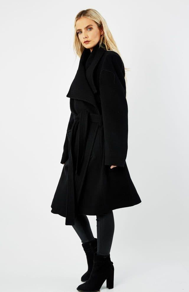 Woman wearing a black coat on a white background.