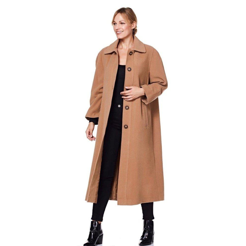 Woman wearing a long tan coat on a white background
