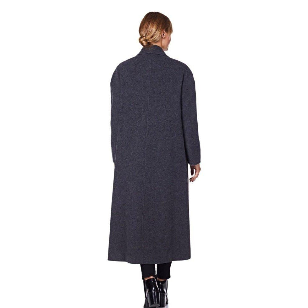 Person wearing a long dark coat on a white background