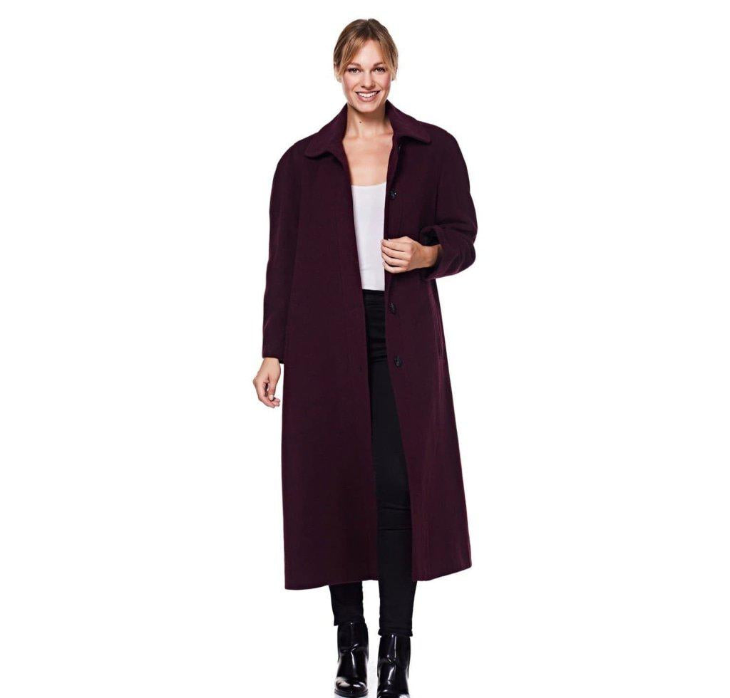 Woman wearing a long dark coat on a white background