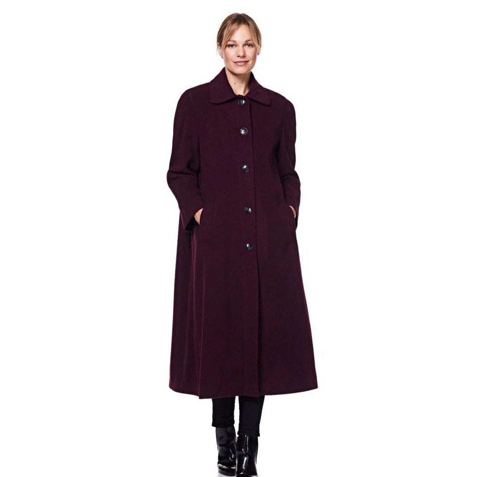 Woman wearing a long dark coat on a white background