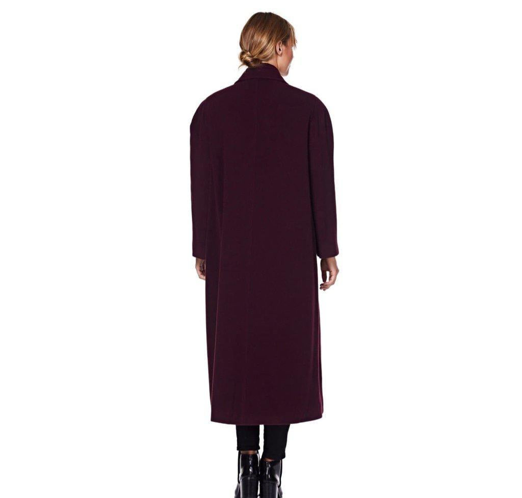 Person wearing a long burgundy coat on a white background