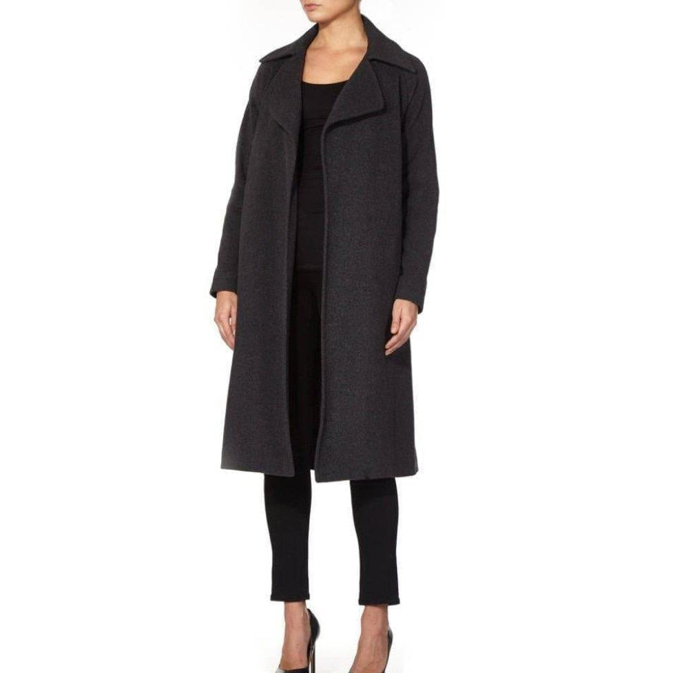 Woman wearing a long dark gray coat on a white background