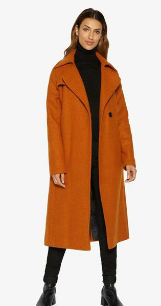 Woman wearing an orange coat with a black turtleneck and pants on a white background,