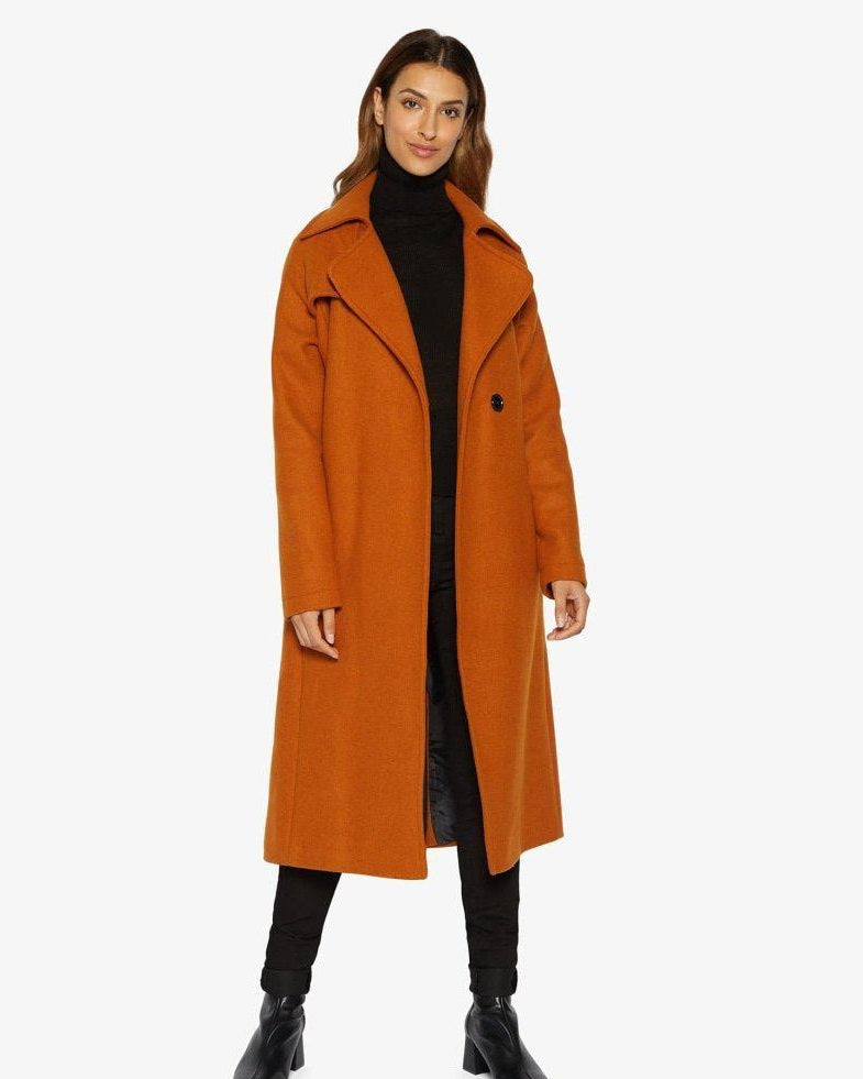 Woman wearing an orange coat on a white background