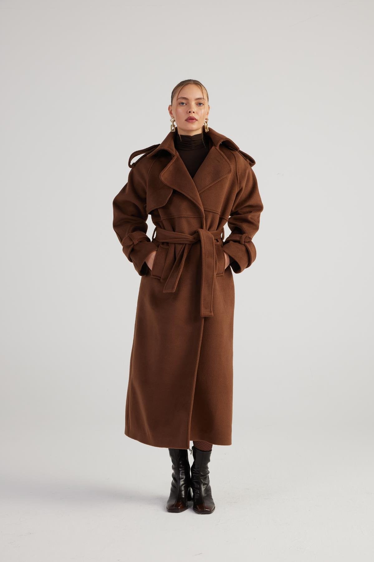 Person wearing a brown coat on a white background