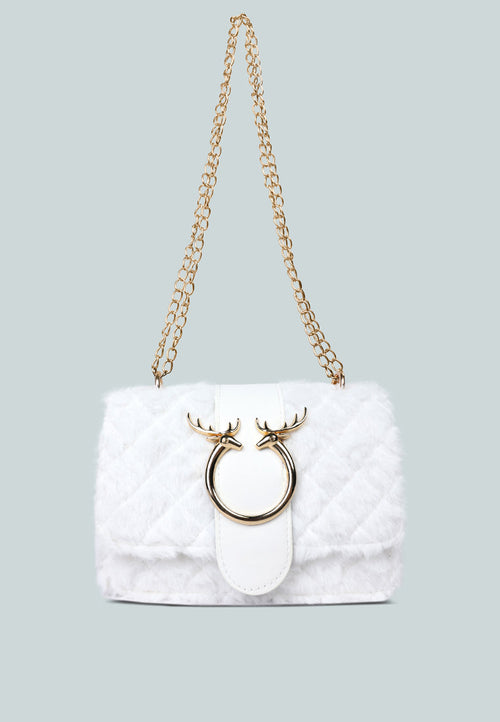 White quilted handbag with gold chain strap and decorative ring on a light gray background