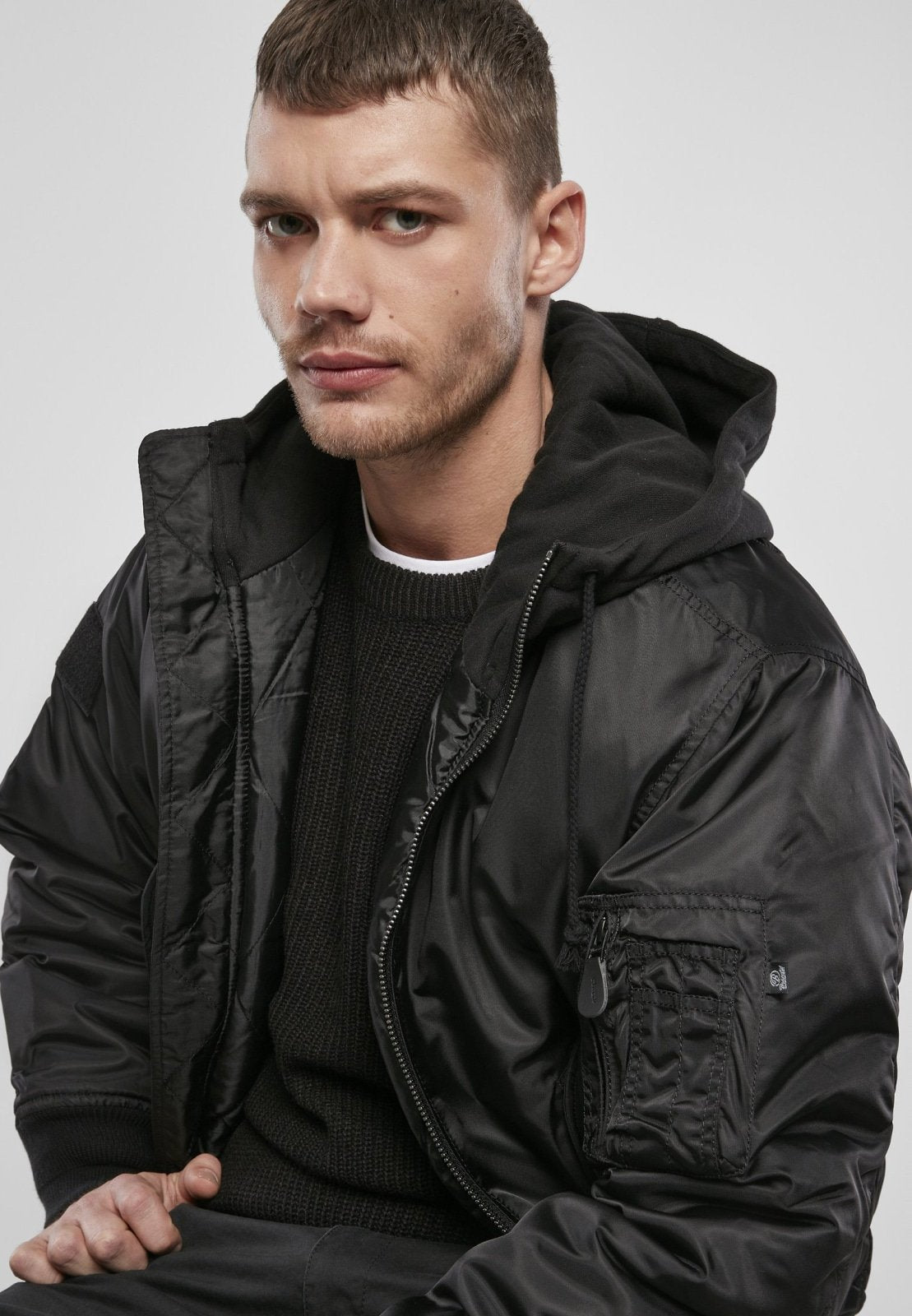 Man wearing a black jacket against a plain background