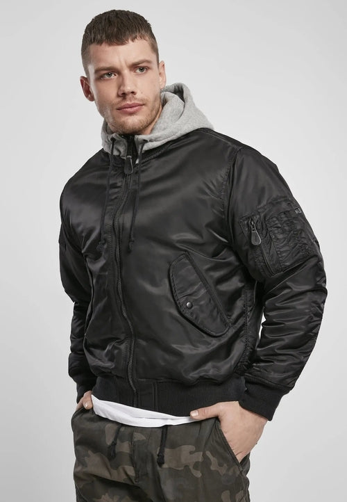 Man wearing a black bomber jacket with a gray hood on a white background